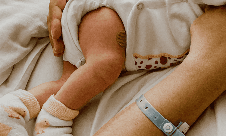 Holding a baby in a hospital bed after birth